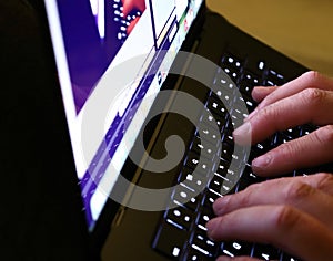 Typing on illuminated laptop keyboard