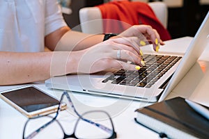 Close up of hands unrecognisable woman sitting in office coworking and typing on her laptop keyboard computer