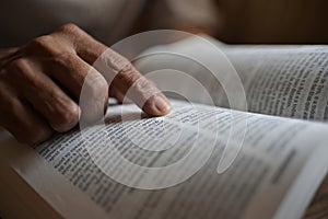 close up on the hands of an unrecognizable black woman reading the bible. photo