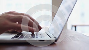 Close-up of hands of unrecognizable business man typing on laptop computer.