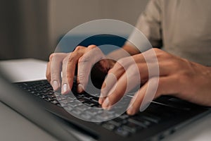Close-up hands of unrecognizable programmer male typing code on laptop keyboard, showcasing process of software