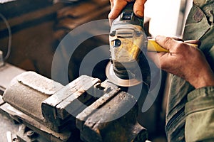 Close-up of hands using an angle grinder