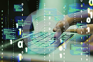 Close up of hands using laptop keyboard with abstract coding binary code hologram on blurry background. Artificial intelligence