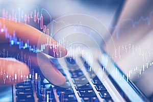 Close up of hands using notebook with forex chart on blurry desktop. Technology and trade concept.