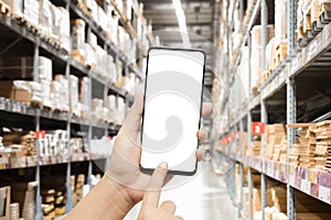 Close-up hands using smartphone in warehouse industry blur background for logistic wholesale storehouse, Online shopping concept.