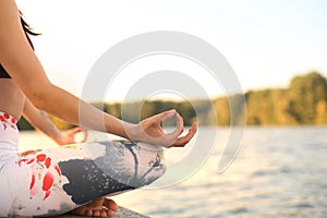 Close up hands of woman do yoga outdoor, lotus pose. Healthy and yoga concept