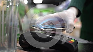 Close up hands of woman making payment with phone machine terminal while swiping debit card to pay the bill. Woman hand