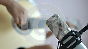 Close-up hands of woman playing acoustic classic guitar and record with microphone, Music instrumental for jazz and easy listening