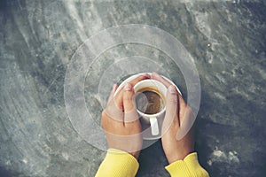 Close up hands of woman sitting office desk holding sweet coffee cup relax and enjoy with happy time. Hot coffee mug in hand.