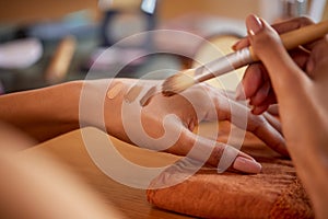 Close up hands of woman swatching cream foundation shades