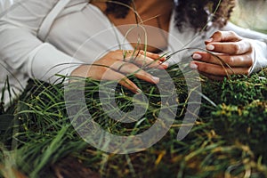 Close up of hands of the woman touching the grass, feeling nature