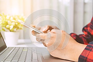 Close up. hands woman touching smartphone on white desk in room. Woman playing social network, searching job, trading stock at