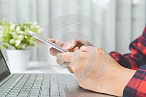 Close up. hands woman touching smartphone on white desk in room. Woman playing social network, searching job, trading stock at