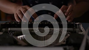 Close up hands of woman typing on retro typewriter during working at home.