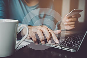 Close up hands of woman using computer and credit card paying bills for online ordering