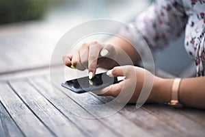 Close up of hands woman using her cell phone. Outdoor.