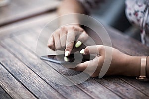 Close up of hands woman using her cell phone. Outdoor.