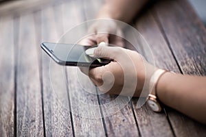 Close up of hands woman using her cell phone. Outdoor.