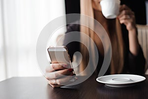 Close up of hands woman using her cell phone in restaurant, cafe.