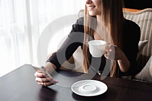 Close up of hands woman using her cell phone in restaurant, cafe