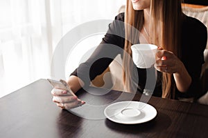 Close up of hands woman using her cell phone in restaurant, cafe.