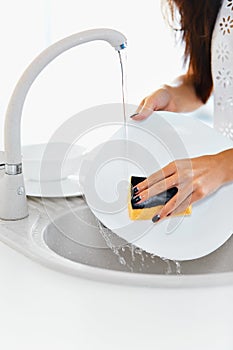 Close up hands of woman washing dishes in the kitchen