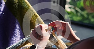 Close-up of the hands of a young woman holding knitting needles and knitting