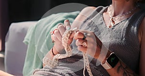 Close-up of the hands of a young woman holding knitting needles and knitting