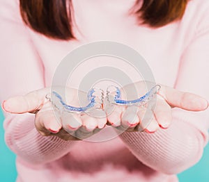 Close up hands of young woman holding silicone orthodontic retainers for teeth