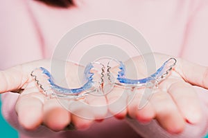 Close up hands of young woman holding silicone orthodontic retainers for teeth