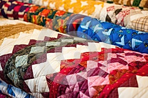 close-up of handsewn quilts in various patterns