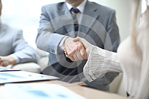 Close up.the handshake of a businessman and business woman over a Desk
