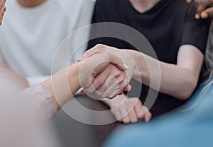 close up. handshake of young people during a group meeting