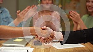 Close-up handshaking of unrecognizable African-American businesswoman with Caucasian businessman partner after signing