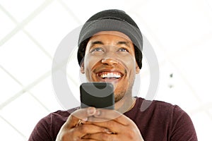 Close up handsome african american man smiling and holding cellphone