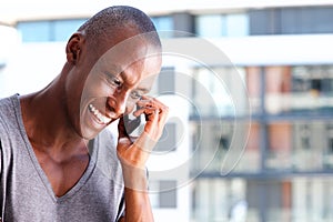 Close up handsome african guy smiling and talking on cellphone