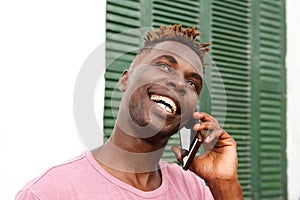 Close up handsome black guy standing outside and talking on mobile phone