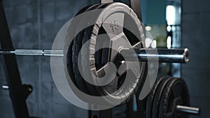 Close up of handsome male prepare to do exercises with barbell in a gym