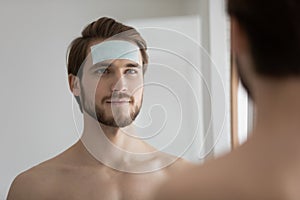 Close up handsome man with anti wrinkle patch on forehead