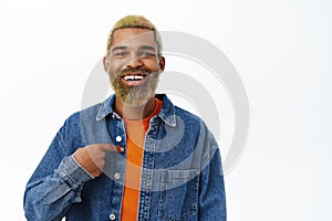 Close up of handsome smiling Black guy points at himself. Hopeful young man self-promoting, talk about him, stands over