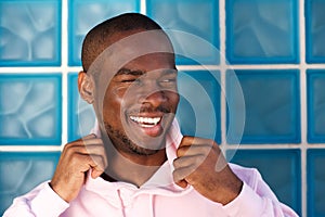 Close up handsome young african american man laughing by wall