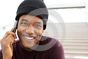 Close up handsome young african american man smiling and talking with cellphone