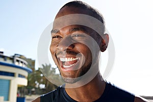 Close up handsome young black man laughing outdoors