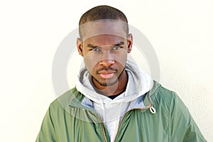 Close up handsome young black man staring by wall
