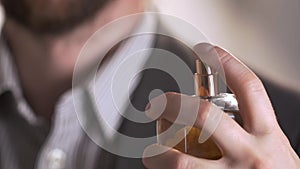 Close up of handsome young business man using perfume