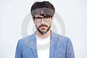 Close up handsome young man with beard and glasses against white background