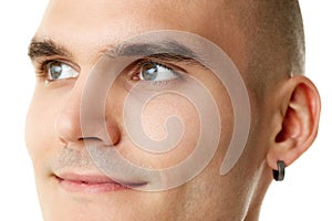 Close-up of handsome young smiling man with spotless face, thick brows and looking aside isolated on white studio