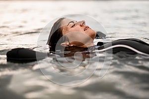 Close-up of handsome young woman in black swimsuit with closed eyes