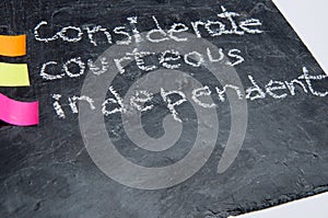 Close up of handwritten educational values: considerate, courteous and independent. Chalk on a blackboard. photo