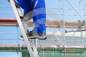 Close-up Of A Handy Repair Man Standing On Steel Ladder